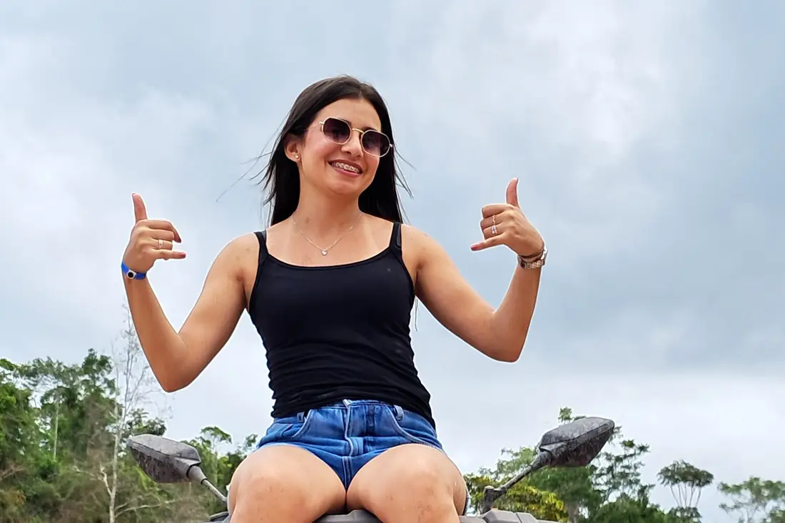 Cliente sorrindo sentada no quadriciclo antes da trilha