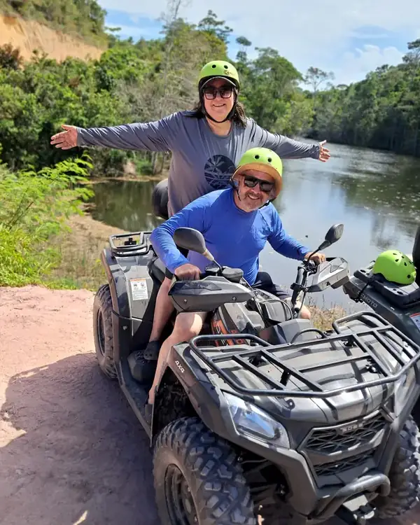 Mãe e filho no quadriciclo à beira do rio