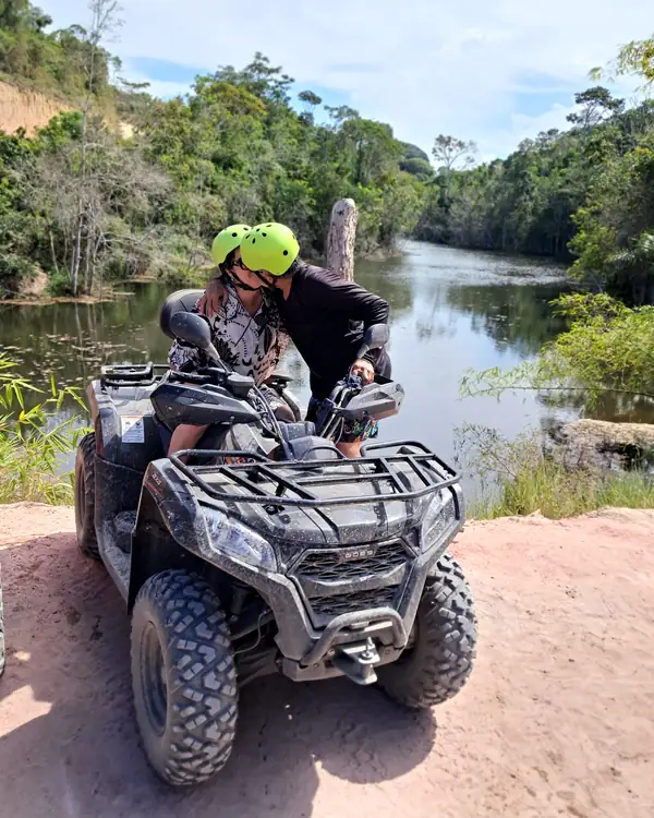 Casal na beira do rio no quadriciclo