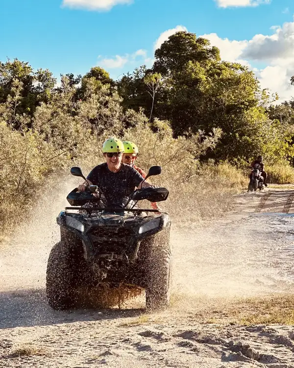 Quadriciclo espirrando lama na rota radical